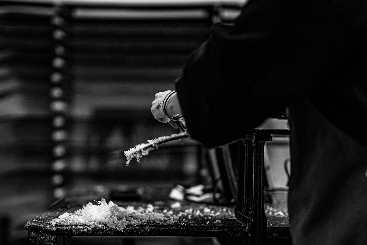 Person srcaping wax in a blurred indoor setting